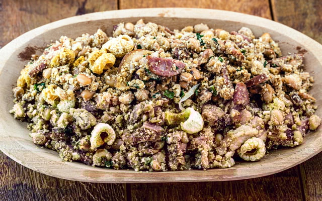 Feijão tropeiro com linguiça, bacon e temperos na travessa