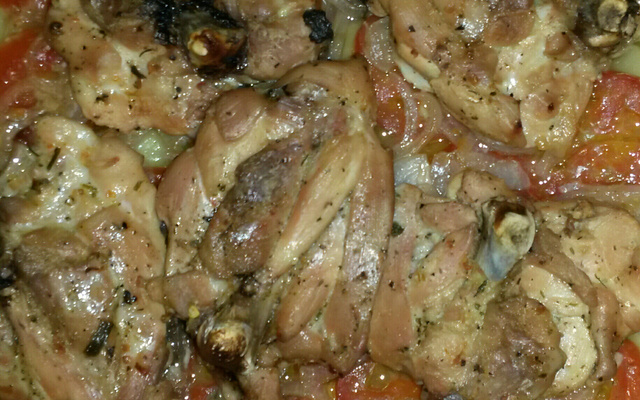 Coxa de frango com batatas e tomates.