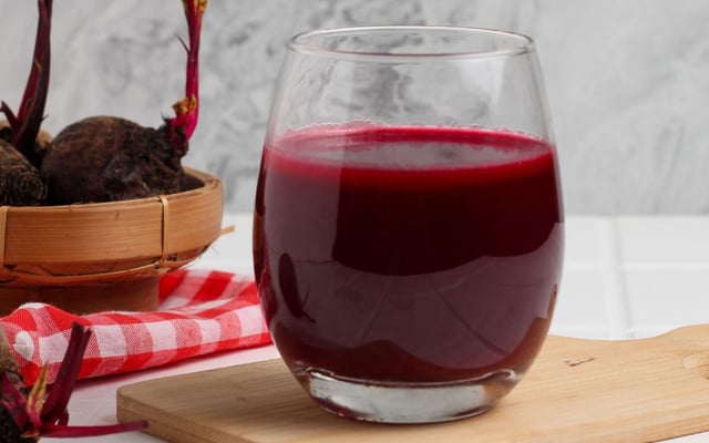 Suco de beterraba no copo com o legume ao fundo