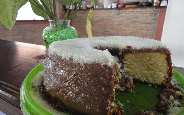 Bolo de baunilha com cobertura de chocolate e coco