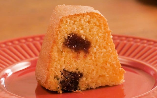 Fatia de bolo de fubá com goiabada em pedaços no meio