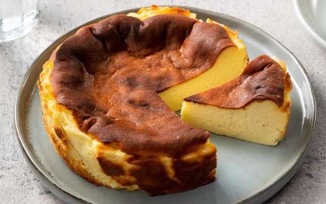 Torta cheesecake basca com fatia cortada em um prato grande