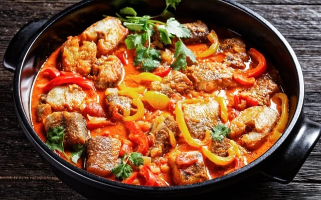 Moqueca baiana com postas de peixe e pimentões fatiados