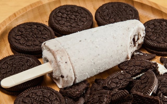 Picolé de Oreo com pedaço mordido servido com biscoitos