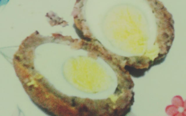 Ovo à milanesa envolvido em linguiça