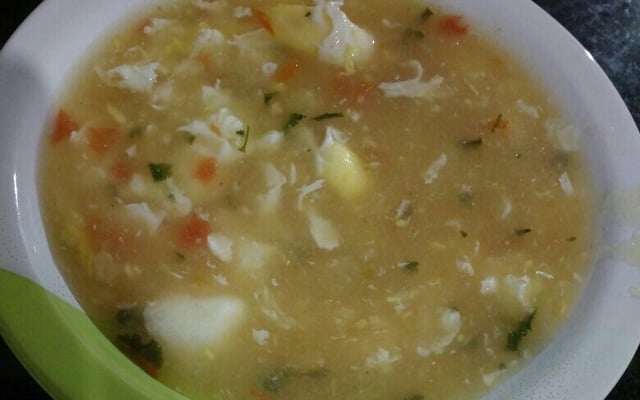 Caldo de ovos com legumes e temperos em prato fundo