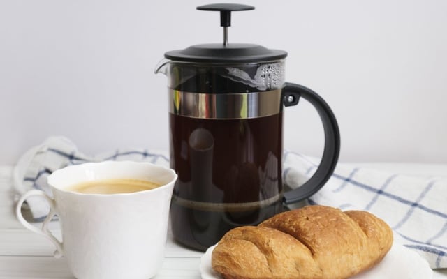 Café na prensa italiana fresco na xícara e com pão