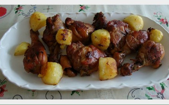 Coxas e sobrecoxas do fogo ao forno, acompanhadas de farofa de passas e maçã