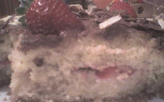 Bolo de baunilha com cobertura de chocolate e morango