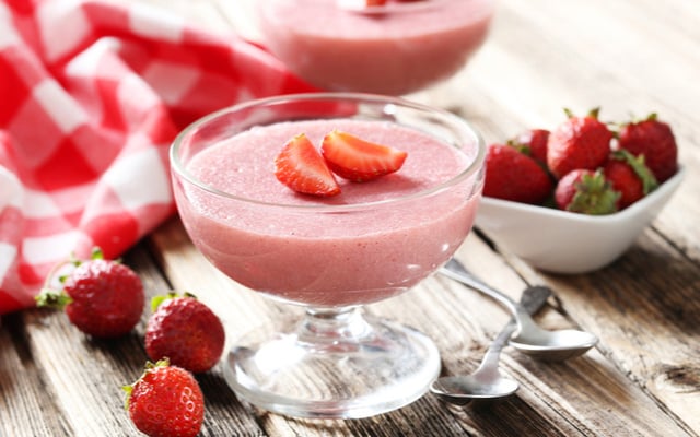 Mousse de morango servida em taça com morangos picados