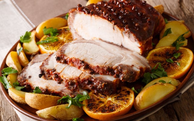 Tender natalino assado e fatiado com batata, laranja e ervas
