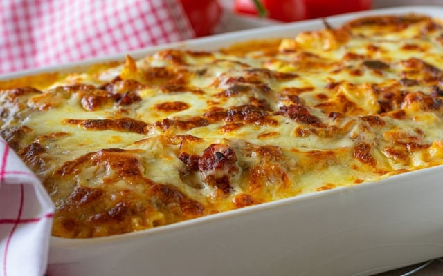 Macarrão de forno com molho e coberto de queijo gratinado