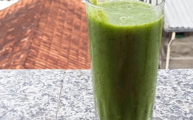 Suco verde detox no copo de vidro ideal para um dia quente