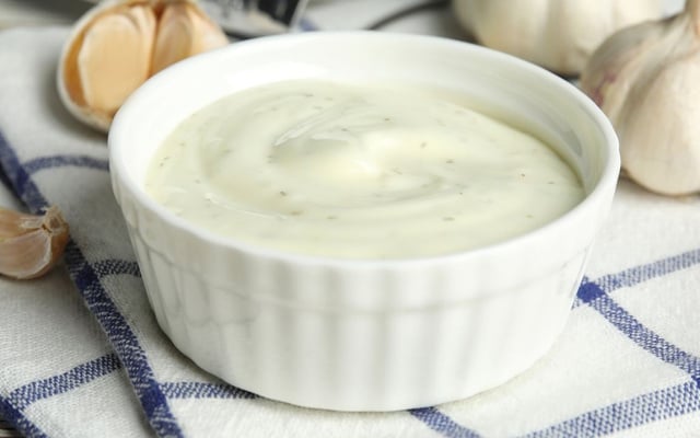 Molho de alho com creme de leite cremoso servido em recipiente