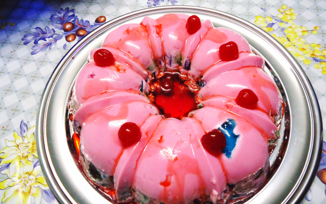 Gelatina colorida com cereja em calda