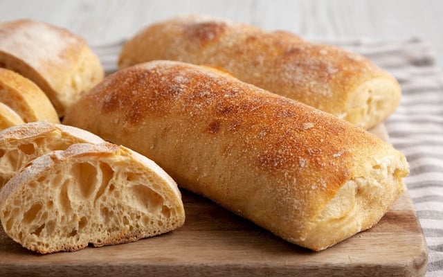 Ciabatta fácil em tábua de madeira com fatias cortadas