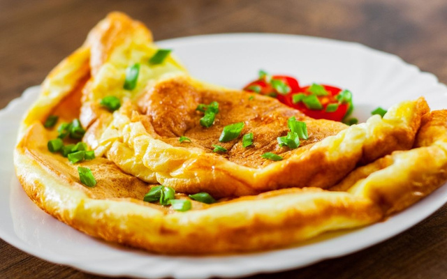 Omelete na airfryer pronta no prato com cebolinha e tomate
