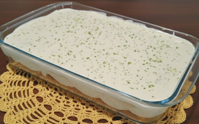 Pavê de limão na travessa com biscoito, creme e raspas da fruta