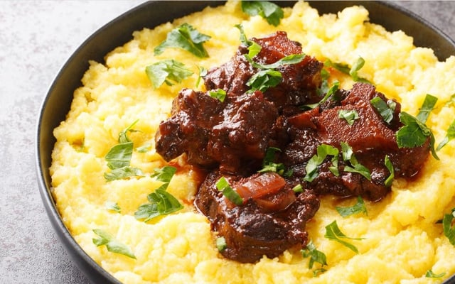 Rabada com polenta e agrião em um prato fundo