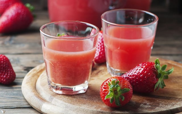 Dois copos de suco de morango natural em uma bandeja