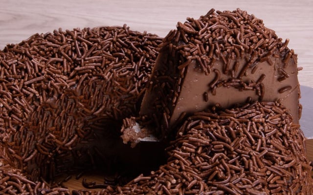 Fatia de brigadeirão cremoso sem forno coberto com granulado