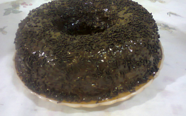 Bolo mesclado com cobertura de chocolate e beijinho