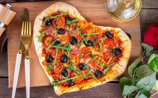Pizza com formato de coração recheado com calabresa e tomate