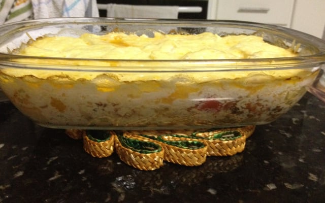 Filé de tilápia ao forno coberto por fatias de queijo em travessa de vidro