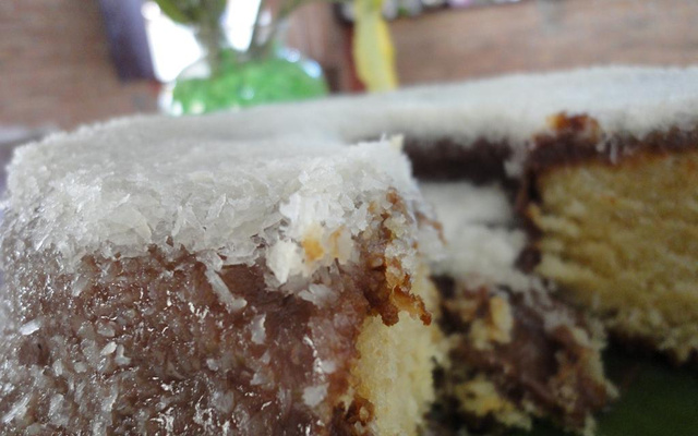 Bolo de baunilha com cobertura de chocolate e coco