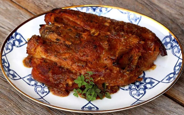 Pernil com molho de damasco em prato decorado