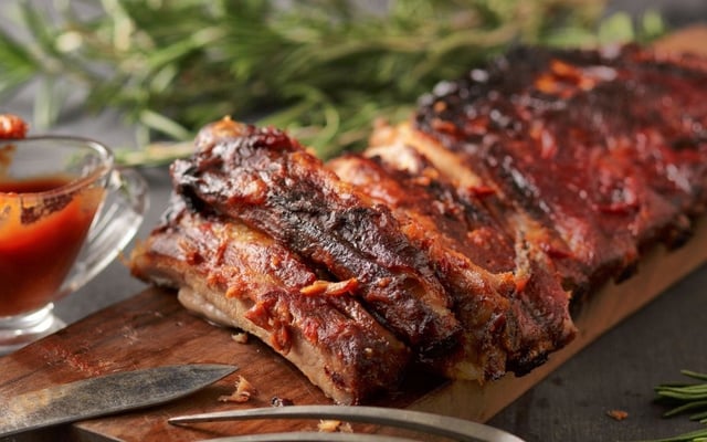 Costelinha de porco temperada cozida e acompanhada de molho