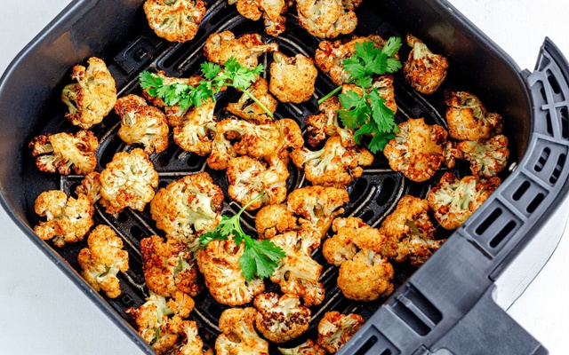 Pedaços de couve-flor na airfryer douradinhos dentro da cesta