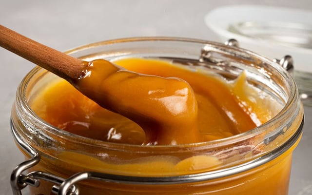 Doce de leite condesado caseiro no pote de vidro com colher