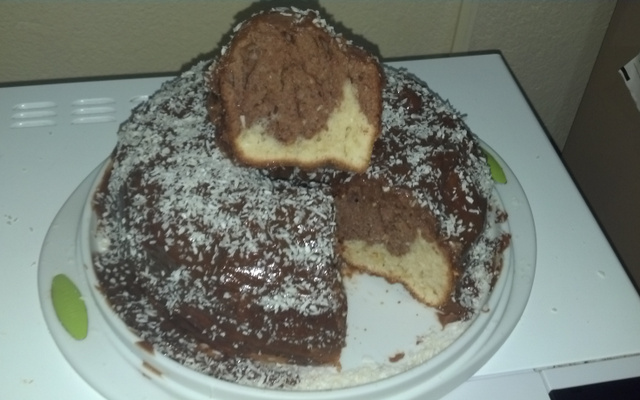 Bolo mesclado com cobertura de chocolate e coco