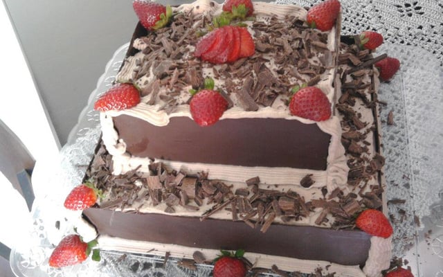 Bolo de chocolate com recheio de flocos e creme com morangos