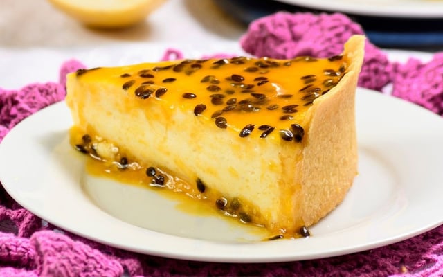 Fatia de cheesecake de maracujá com calda e massa crocante