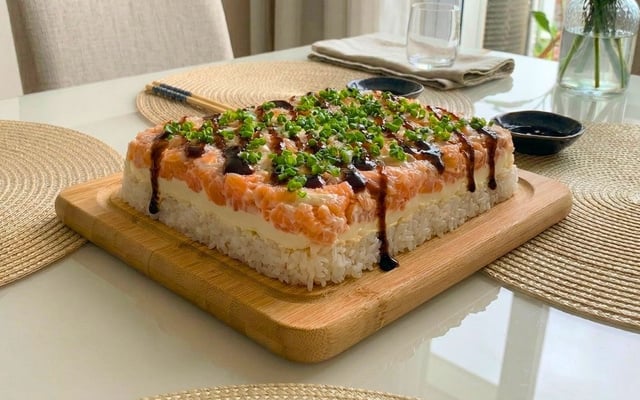 Sushi de preguiçoso finalizado com molho tarê e cebolinha