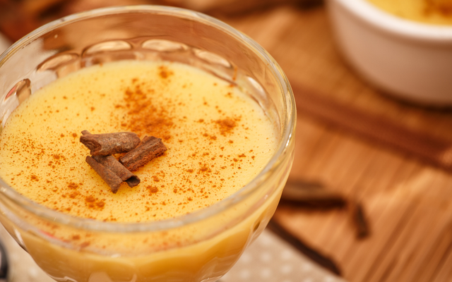 Curau de milho cremoso com canela por cima em um refratário