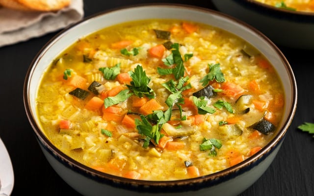 Canja de galinha cremosa com arroz e legumes na tigela