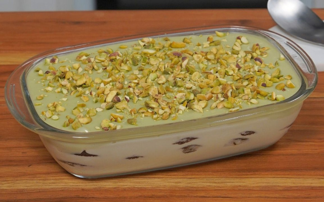 Pavê de pistache na travessa com creme, biscoitos e pistache