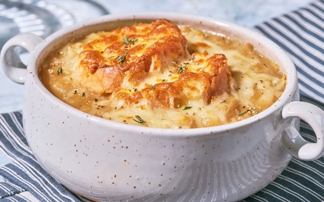 Sopa de cebola francesa com fatias de pão e queijo gratinado