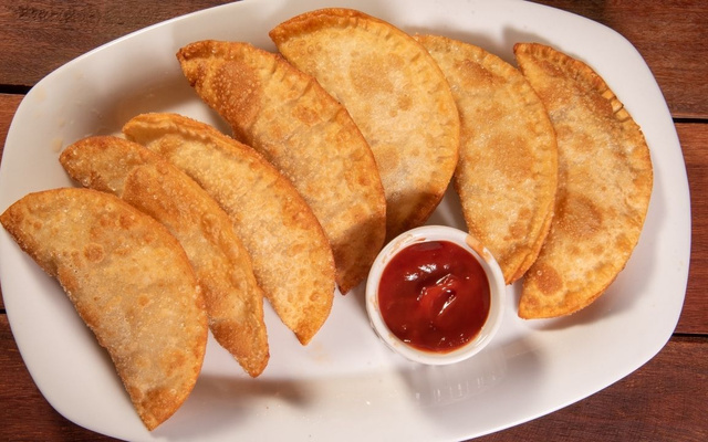 Pastel na airfryer de vários sabores com pote de molho no prato