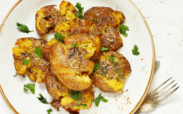 O petisco francês que vai roubar a cena na sua semana: batatinhas amassadas com cebola caramelizada e queijo derretido