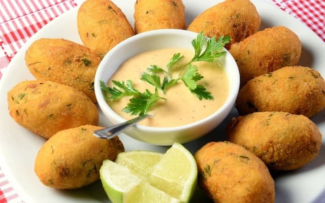 Bolinho de bacalhau acompanhado com um molho não só é pratico de comer como é uma delícia (Créditos: TudoGostoso)