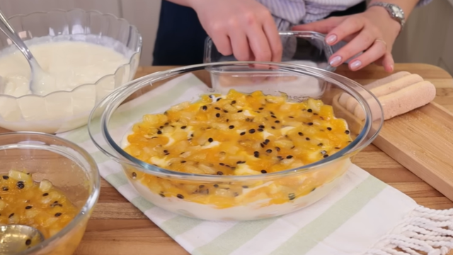 Montagem do pavê de frutas amarelas com creme branco. (créditos: Reprodução Youtube Letícia Solcia)