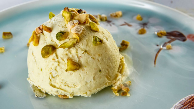 Sorvete de pistache cremoso em um prato finalizado com mais sementes por cima (Créditos: Shutterstock)