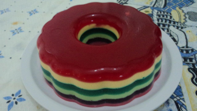 Gelatina colorida em camadas de diversos sabores desenformada em prato (Créditos: TudoGostoso/Luana Neves)