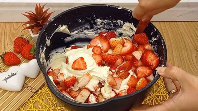 Misture os morangos com cuidado para mantê-los em pedaços uniformes, sem desmanchar (Créditos: Reprodução / YouTube @Famíliaboadeboca)