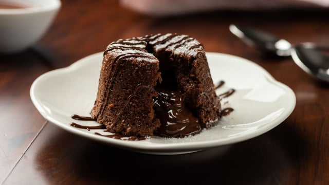 Petit gateau com calda de chocolate aberto e recheio escorrendo (Créditos: Shutterstock)