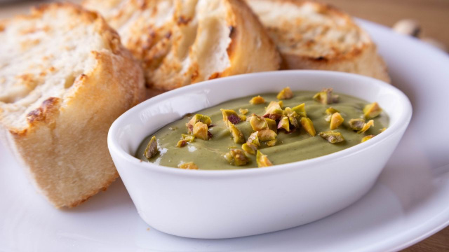 Patê de pistache cremoso em potinho acompanhados com torradinhas para servir (Créditos: Shutterstock)